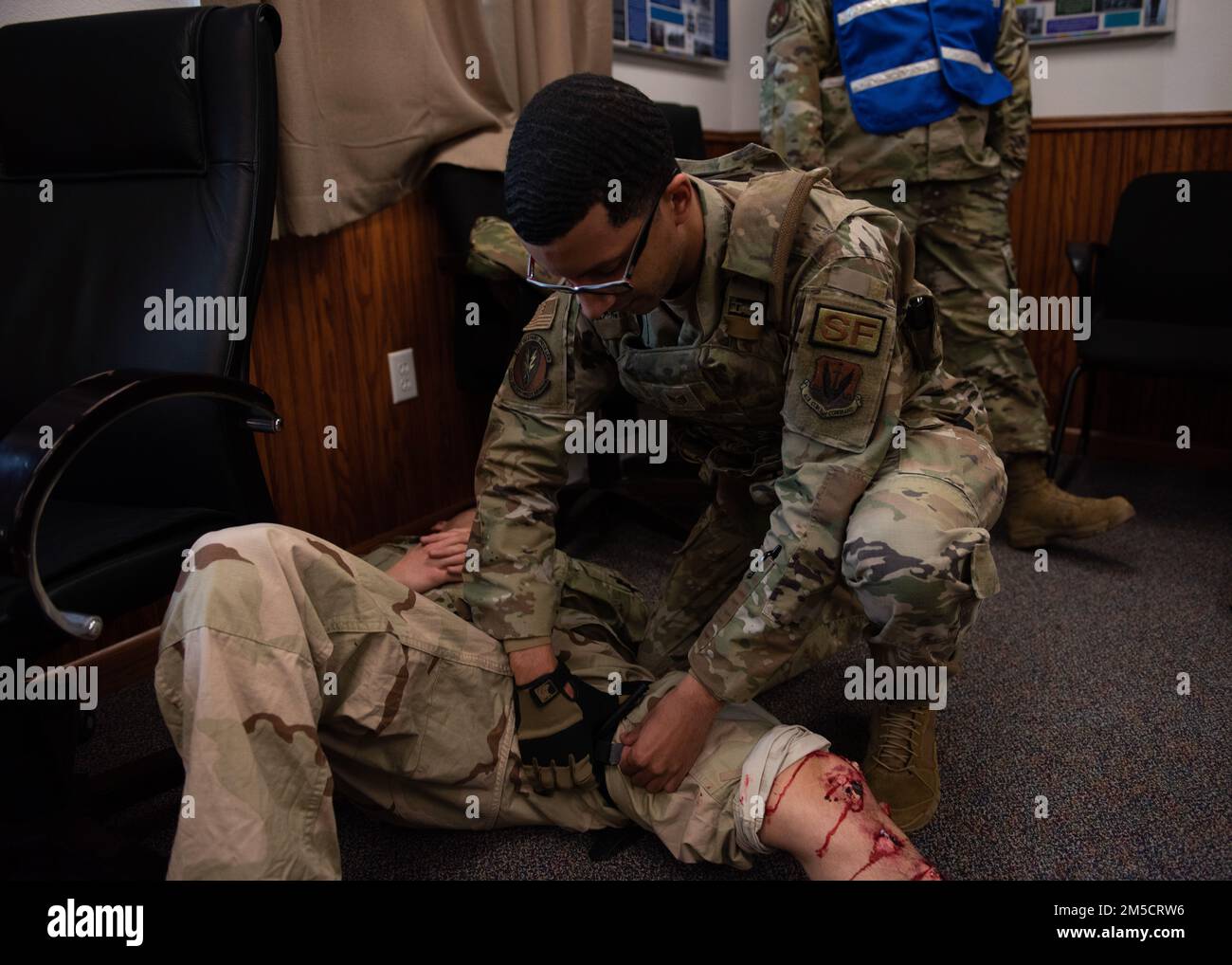 ÉTATS-UNIS Le sergent d'état-major de la Force aérienne Tristin Carey, 366th escadron des forces de sécurité (SFS) officier non commandant en charge de la détention applique un tourniquet autour d'une jambe d'un homme d'aviation simulé et blessé à la base aérienne de Mountain Home, Idaho, le 2 mars 2022. Des aviateurs du SFS, du 366th Escadron du génie civil et de plusieurs autres escadrons ont participé à l'exercice de tir actif. Banque D'Images