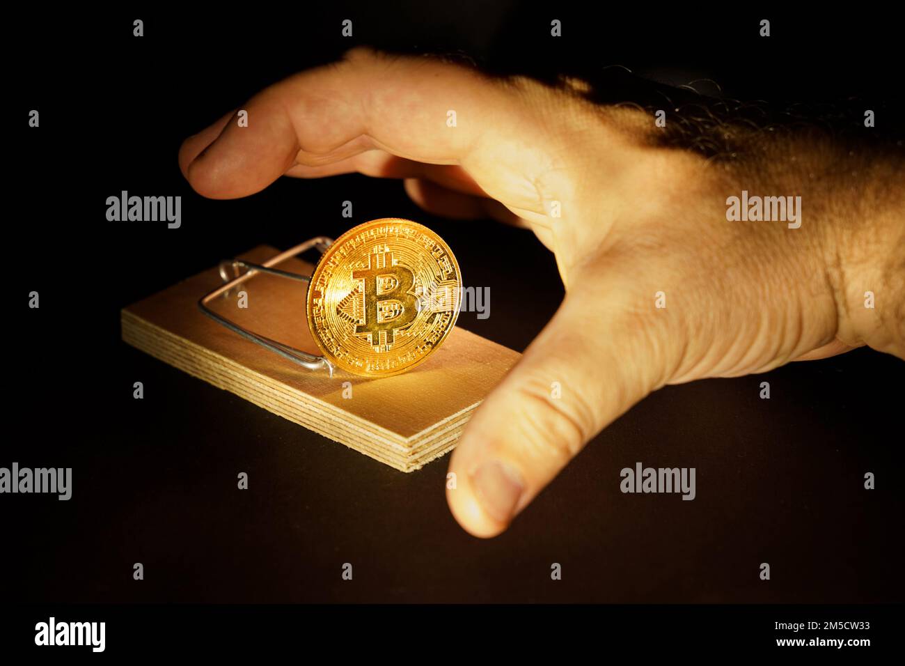 La main atteint pour le bitcoin du mousetrap. Risques et dangers liés à l'investissement dans la crypto-monnaie. Banque D'Images