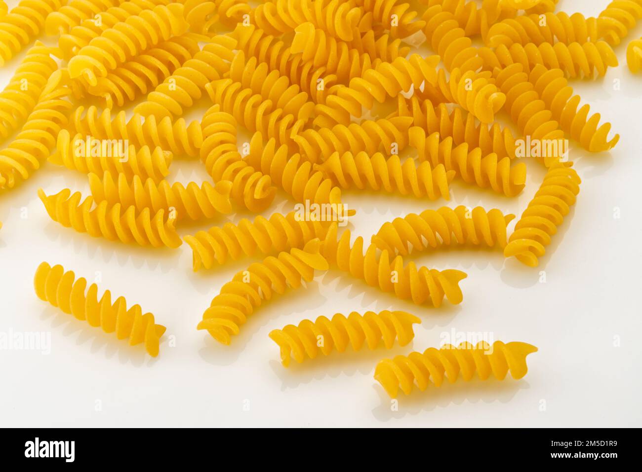 Pâtes italiennes fusilli sèches et non cuites, macaroni isolé sur le toit blanc Banque D'Images