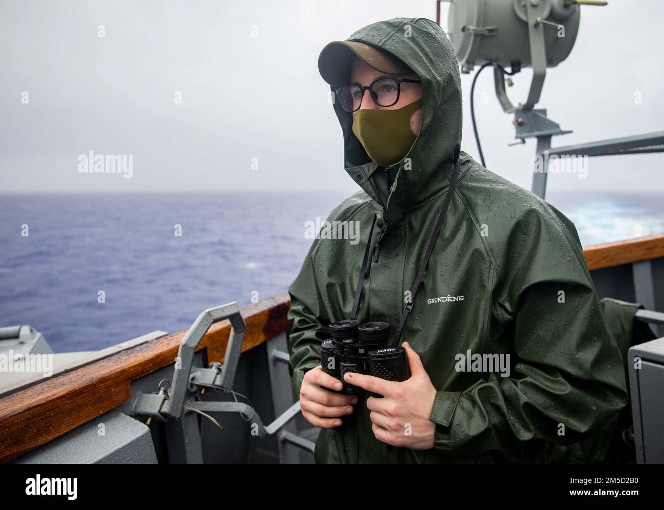 220303-N-KW492-2054 OCÉAN PACIFIQUE (3 mars 2022) Sam Cohen, le Matelot de 1re classe Boatswain, de Lawrenceville, en Géorgie, cherche des contacts de surface sur l’aile du pont du destroyer de missile guidé de classe Arleigh Burke USS Milius (DDG 69). Milius est affecté au Destroyer Squadron (DESRON) 15 et est en cours de soutien à un Indo-Pacific libre et ouvert. CTF 71/DESRON 15 est la plus importante force de combat de la Marine en déploiement avancé et la principale force de combat de la flotte américaine 7th. Banque D'Images