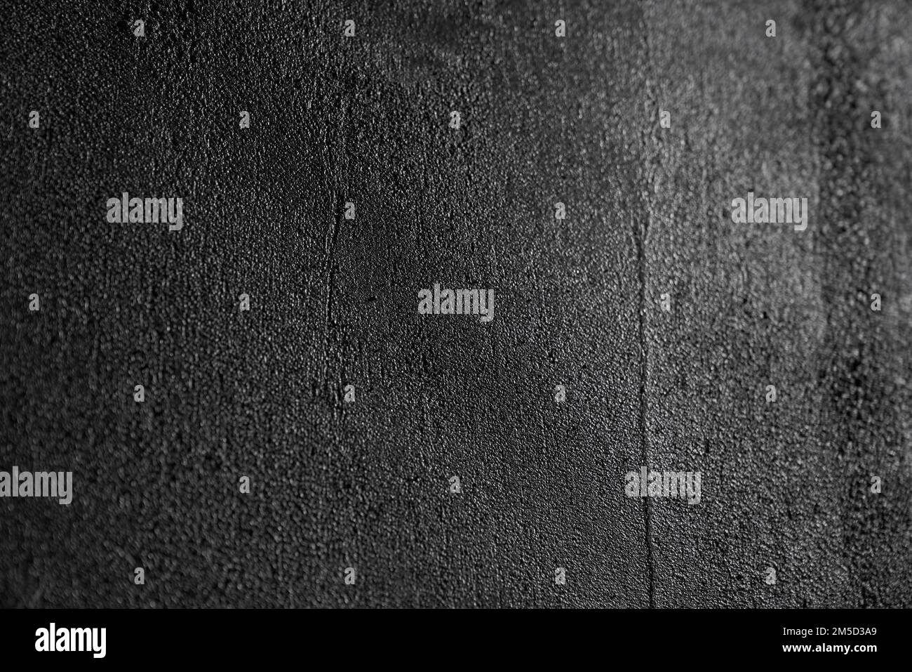 Texture d'asphalte humide pour un arrière-plan moderne. Gros plan sur un motif en tissu gris foncé ou graphite avec reflets clairs et chatoyants. Concept de textures et d'arrière-plan. Banque D'Images