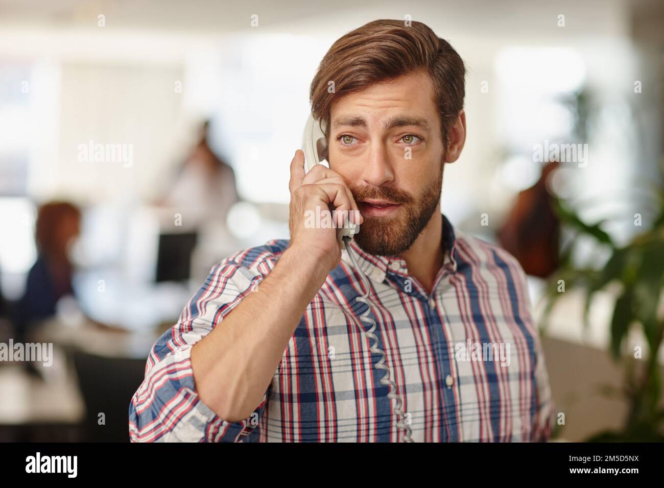 La réussite est toujours un appel. un jeune homme d'affaires parlant au téléphone dans un bureau. Banque D'Images