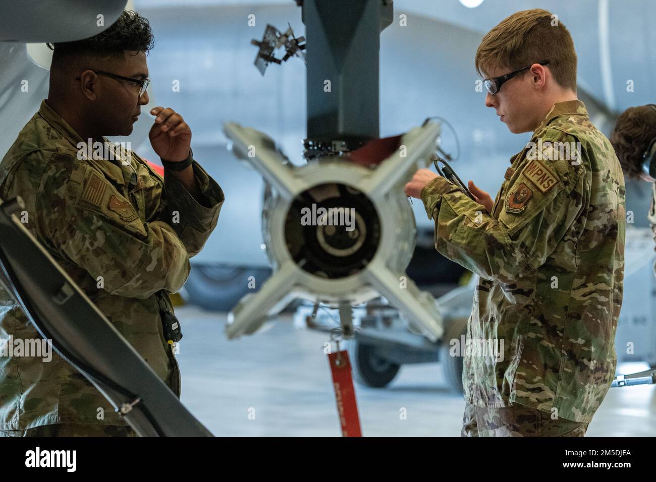 ÉTATS-UNIS Airman Devon seaborne, 27th, opérations spéciales membre d'équipage principal du Groupe d'entretien, évalue le principal Airman Zachary Spoon, 12th unité de maintenance des aéronefs, 727th membre d'équipage du chargement d'armes de l'escadron de maintenance des aéronefs opérations spéciales, Alors qu'il prépare une bombe lors de la compétition de l'équipage de chargement annuel 2021 de SOXG 27 à la base aérienne de Cannon, au Nouveau-Mexique, au 4 mars 2022. Des équipes d'évaluateurs dédiées ont évalué chaque équipe chargée de la charge en ce qui concerne la sécurité, les compétences techniques et la rapidité de la compétition. Banque D'Images