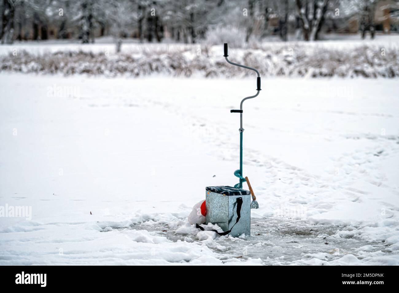 Équipement de pêche pour la pêche sous la glace d'hiver sur le fond d'une rivière gelée. Pêche sous la glace. Banque D'Images