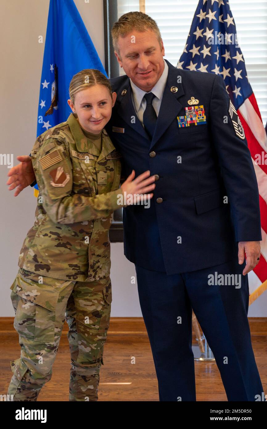 Le Sgt William McGurgan, chef des opérations de la défense, gestionnaire enrôlisé, 131st Bomb Wing Communications Flight, hante une de ses filles lors de sa cérémonie de promotion, 5 mars 2022, à la Garde nationale aérienne Jefferson Barracks, St. Louis, Missouri. McGurgan a eu beaucoup de famille et d'amis viennent montrer le soutien pendant sa promotion. Banque D'Images