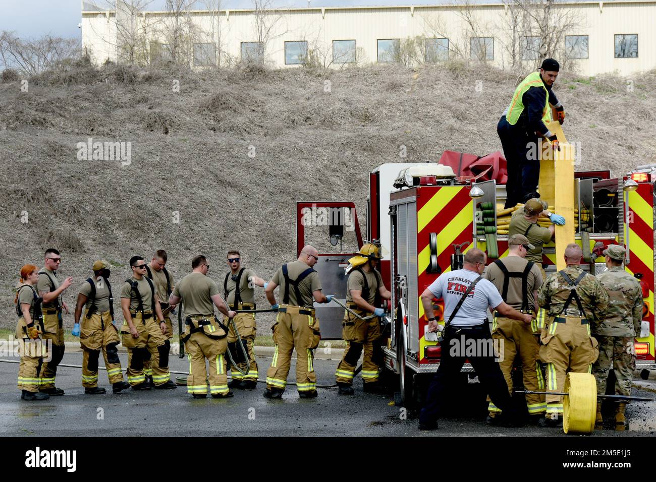 ÉTATS-UNIS Les aviateurs affectés à la Garde nationale aérienne de Caroline du Nord (NCANG), 145th, Escadron de génie civil (ces), avec l'aide des membres du Service des incendies de Charlotte, roulent leurs tuyaux d'incendie après avoir réussi à éteindre un accident d'avion simulé juste à l'extérieur de la base de NCANG, aéroport international de Charlotte Douglas, 6 mars 2022. Le ces 145th a coordonné avec le service des incendies de Charlotte et d'autres autorités locales pour simuler un accident d'avion et les étapes à suivre en cas de catastrophe. C'est le premier exercice de ce genre depuis le 1990s impliquant beaucoup Banque D'Images