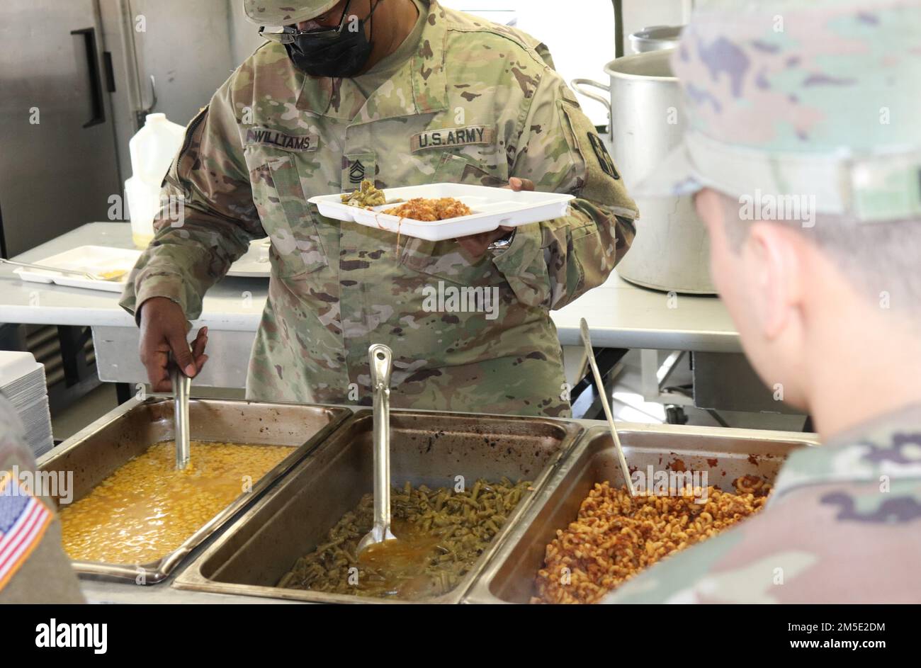 Le Sgt. Williams sert de la nourriture à un soldat dans une cuisine conteneurisée lors d'une assemblée de combat mensuelle à Seagoville, Texas, on 6 mars 2022. Banque D'Images