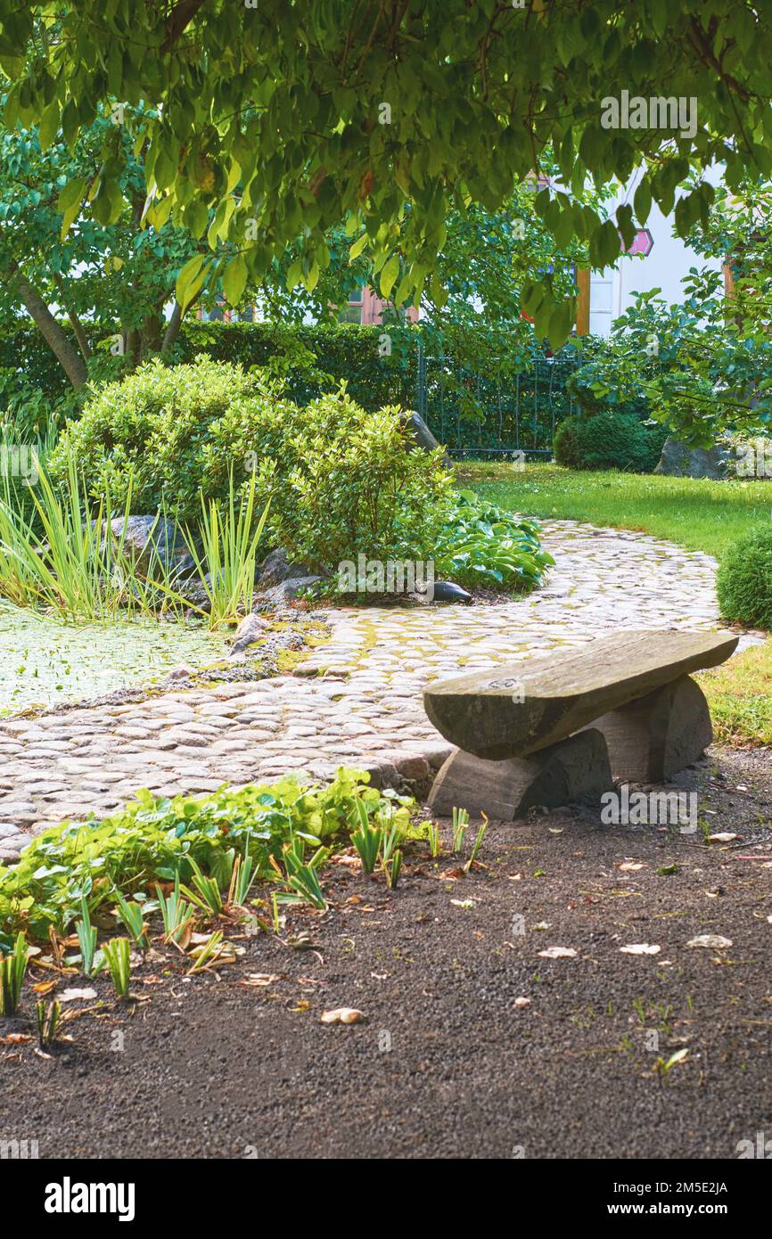 Jardin japonais avec chemin en pierre, banc et étang Banque D'Images