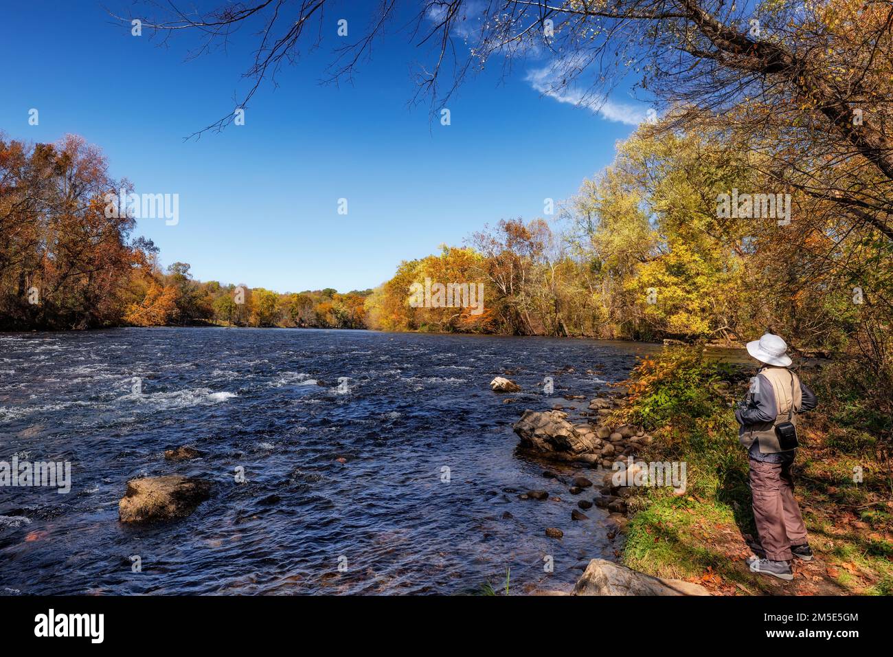 Elizabethon, Tennessee, États-Unis - 20 octobre 2022 : photographe féminin qui capture des photos du paysage d'automne le long des rives du fleuve Watauga Banque D'Images