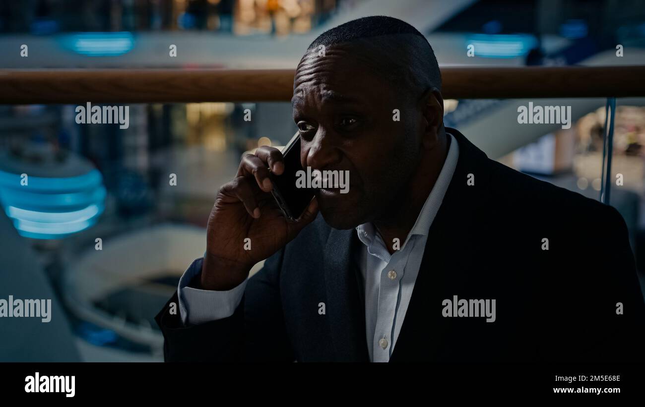 Discussion d'affaires avec le téléphone mobile de l'adulte d'âge moyen 50s Africain entreprise PDG investisseur entrepreneur parler négociation smartphone cellule Banque D'Images