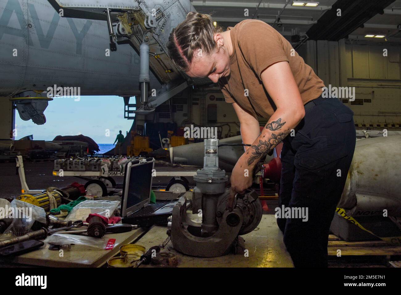 AVIATION DE LA MER DES PHILIPPINES (7 mars 2022) le compagnon de machiniste Airman Christa Jones, de Portland (Ore.), affecté aux « Raptors » de l'escadron de frappe maritime d'hélicoptère (USM) 71, effectue l'entretien d'un moteur de pliage de lame dans la baie hangar à bord du porte-avions de la classe Nimitz USS Abraham Lincoln (CVN 72). Abraham Lincoln Strike Group est en cours de déploiement prévu dans la zone d'exploitation de la flotte américaine 7th afin d'améliorer l'interopérabilité par le biais d'alliances et de partenariats tout en servant de force de réaction prête à l'emploi pour soutenir une région libre et ouverte d'Indo-Pacifique. Banque D'Images