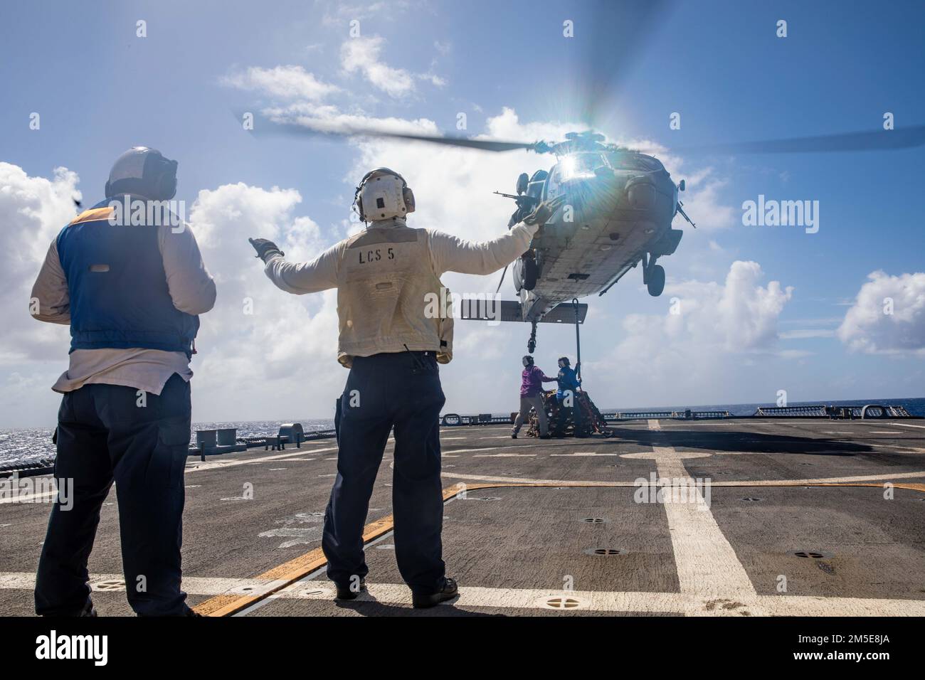 220307-N-HD110-2316 MER DES CARAÏBES - (le 7 mars 2022) -- le compagnon de Boatswain 1st classe Michael Gambrell, à gauche, observe le compagnon de Boatswain 2nd classe James Dowdee signaler aux pilotes dans un hélicoptère MH-60s Sea Hawk attaché aux “Chevaliers de mer” de l’Escadron de combat en mer (HSC) 22, détachement 5, Lors d'une reconstitution verticale (VERTREP) à bord du navire de combat littoral Freedom-variant USS Milwaukee (LCS 5), le 7 mars 2022. Milwaukee est déployée dans la zone d’opérations de la flotte américaine 4th pour soutenir la mission de la Force opérationnelle interagences conjointe Sud, qui comprend la lutte contre le trafic illicite de drogues missio Banque D'Images