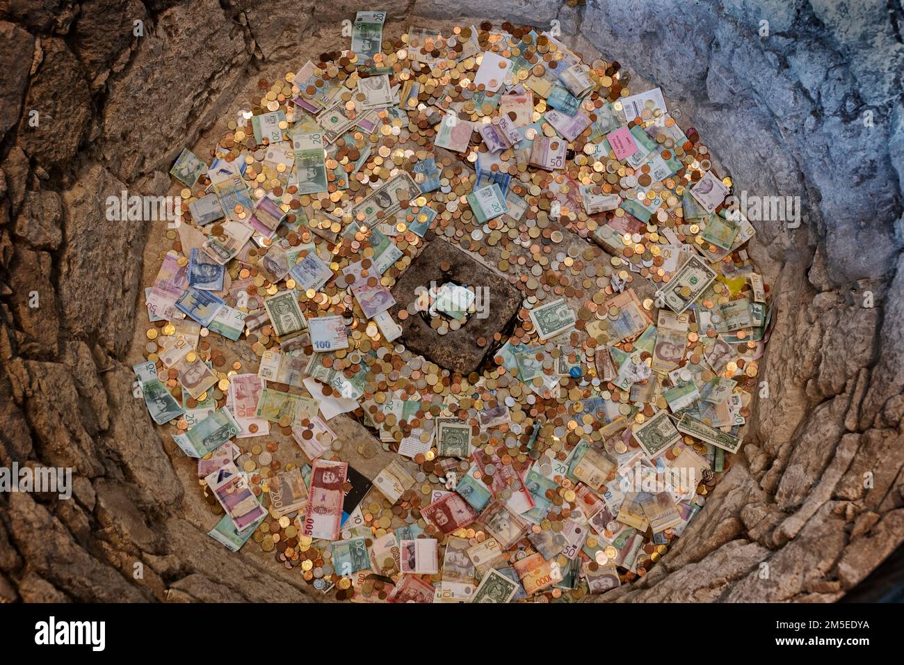 Souhait bien rempli d'argent à la fois des billets et des pièces de différentes monnaies, jeté pour la chance et de faire un souhait au château médiéval de Ljubljana, Sloveni Banque D'Images