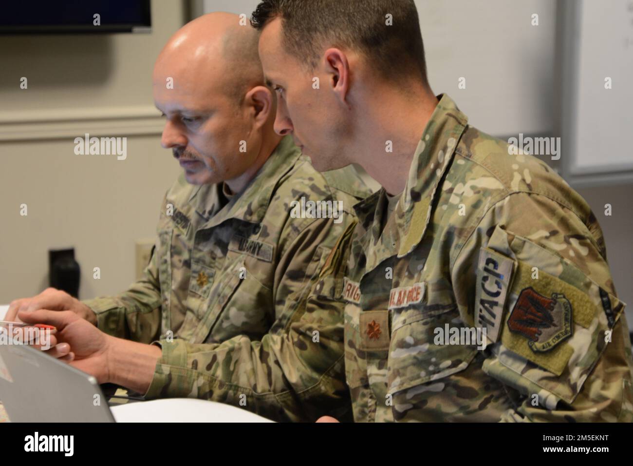 Le Maj. De l'armée Justin Cassidy, officier des opérations futures, et le Maj. De la Force aérienne Shawn Bearinger, officier des opérations futures de la Force aérienne, discutent des options du plan lors d'un cours de formation du personnel 8 mars à fort Indiantown Gap, en Pennsylvanie. Le cours d'essai, organisé par les États-Unis Le Commandement du Nord sera la phase II du cours conjoint de formation du personnel. Le cours a permis de former le personnel à la préparation aux situations d'urgence en utilisant un scénario théorique d'ouragan de catégorie 2. Banque D'Images