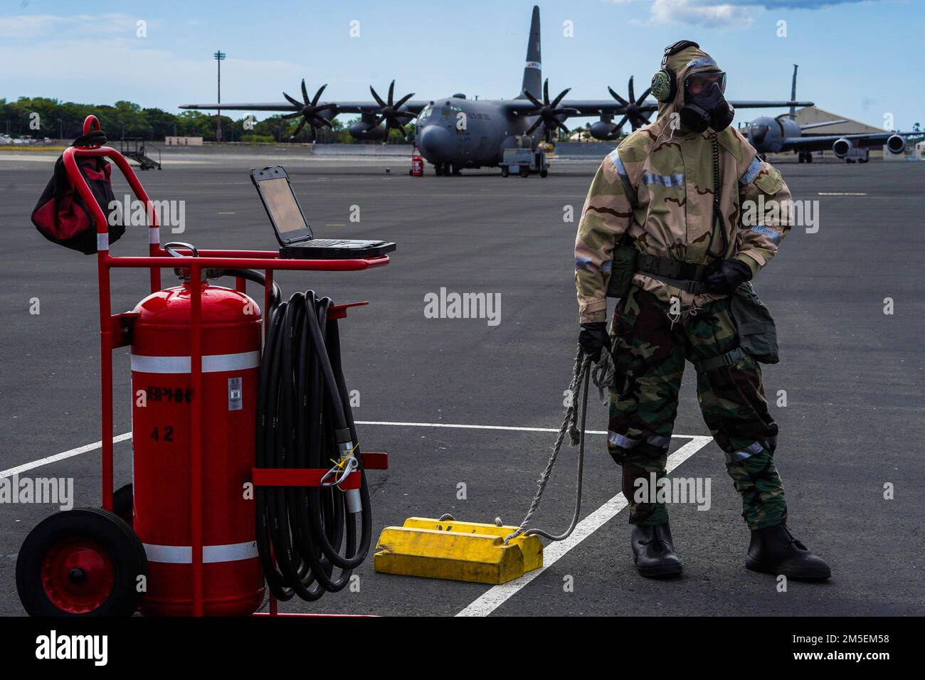 Le sergent d'état-major Justin Rigby, artisan des systèmes de communication et de navigation défensifs de l'escadron 15th de maintenance d'aéronefs, se prépare à placer des cales sous un C-17 Globemaster III lors de l'exercice TROPIC FURIE à la base conjointe Pearl Harbour-Hickam, à Hawaï (8 mars 2022). 15th les aviateurs du groupe d'entretien effectuent diverses tâches après qu'un aéronef atterrit, y compris le placement de cales et la fourniture d'électricité à l'aéronef. Banque D'Images