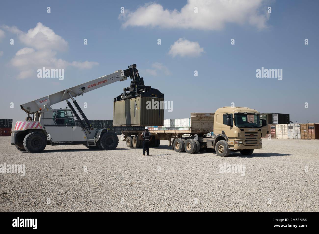 Les entrepreneurs chargent un conteneur de munitions sur une remorque à la suite d'un dessaisissement du programme Counter - ISIS train and Equip Fund (CTEF) au ministère des Peshmerga à la base aérienne d'Erbil, en Irak, au 8 mars 2022. Le programme du CTEF de l’opération inhérente Resolve a cédé plus de $500 millions d’équipements, de véhicules, d’armes et de munitions dans le but de conseiller, d’aider et de permettre aux forces partenaires de vaincre durablement Daesh. Banque D'Images