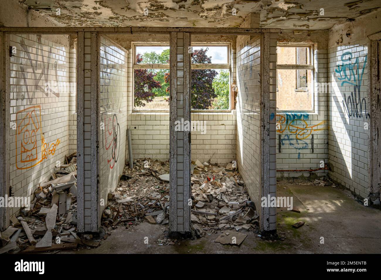 Cabines de toilettes carrelées vandalisées dans un bâtiment abandonné Banque D'Images