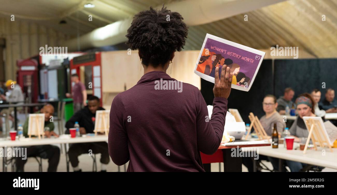 Le senior Airman Mia Evans, 332D, Escadron de soutien de la Force expéditionnaire, fournit des instructions du SIP Paint 'N lors d'un événement du Conseil de la diversité et de l'inclusion en hommage au mois de l'histoire des femmes à un endroit non divulgué, 8 mars 2022. Banque D'Images