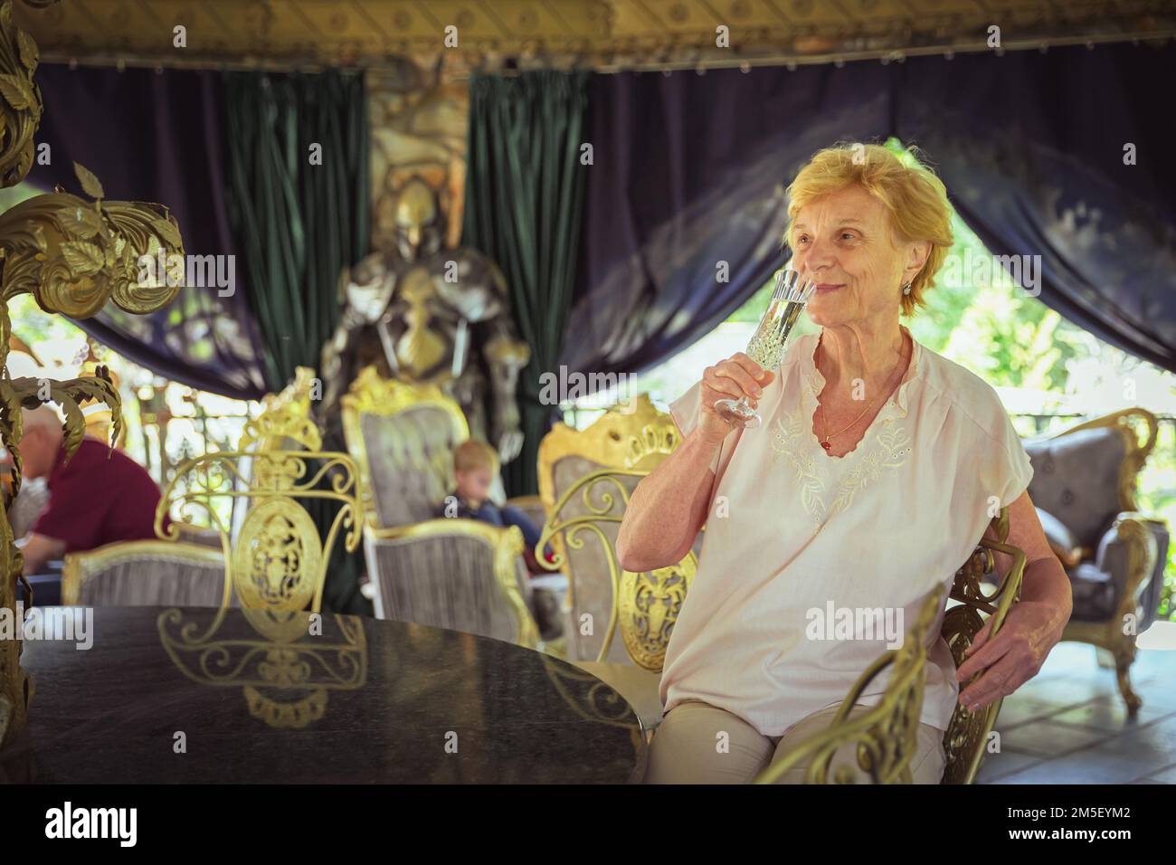 Femme âgée voyageur assis seul sur la terrasse du café-restaurant Banque D'Images