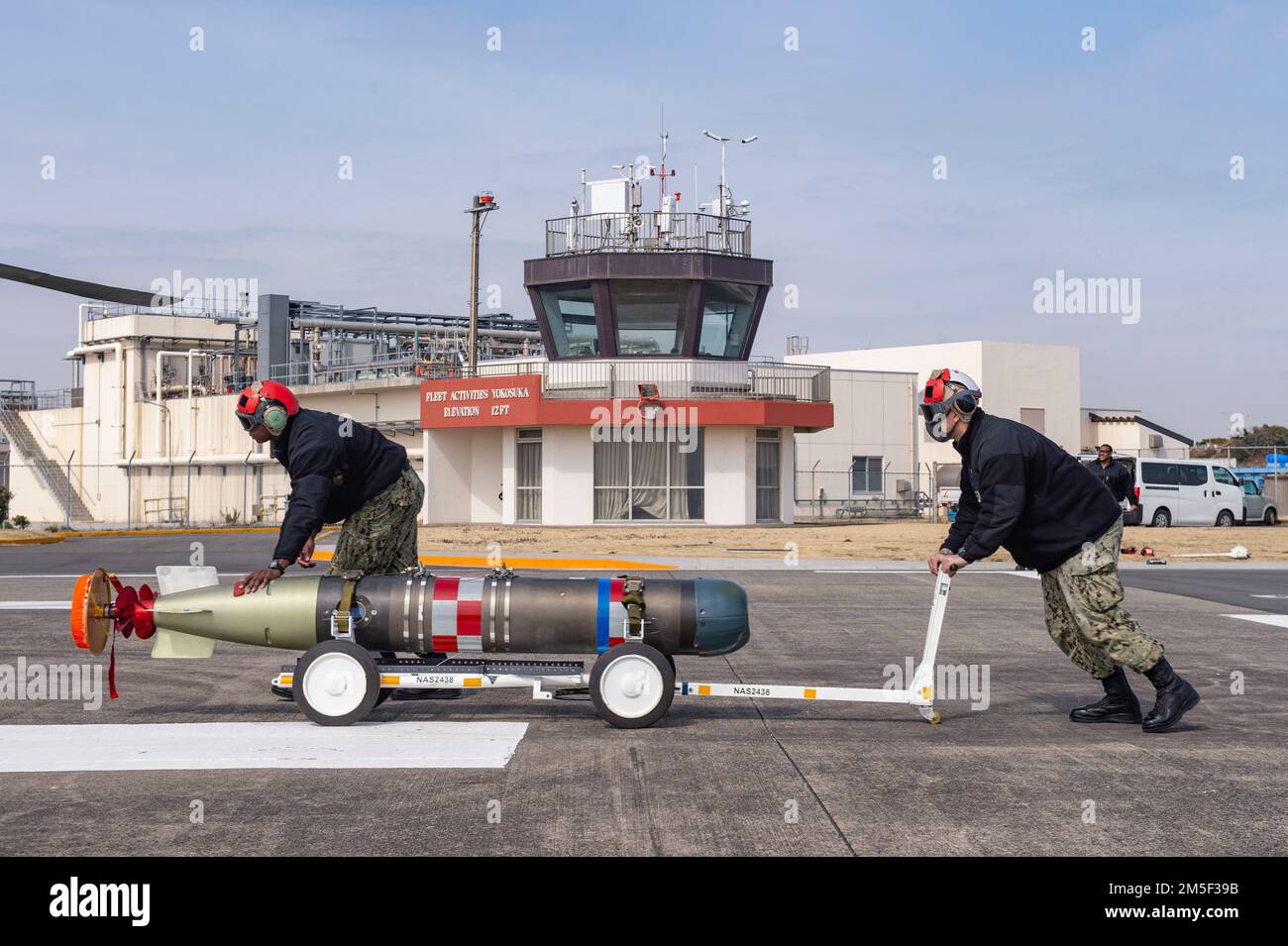 YOKOSUKA, Japon (10 mars 2022) des marins affectés aux « Saberhawks » de l'Escadron de frappe maritime des hélicoptères (HSM) 77 transportent un torpille léger MK 54 en préparation pour le montage sur un Hawk de mer MH-60R lors d'un exercice d'entraînement au commandant des activités de la flotte Yokosuka. Le MK 54 est une torpille d'entraînement inerte conçue pour être récupérée et réutilisée pour les exercices d'entraînement. La HSM-77 est rattachée au commandant de la Force opérationnelle 70 et déployée dans la zone de responsabilité de la flotte américaine 7th à l'appui d'une Indo-Pacific libre et ouverte. Banque D'Images