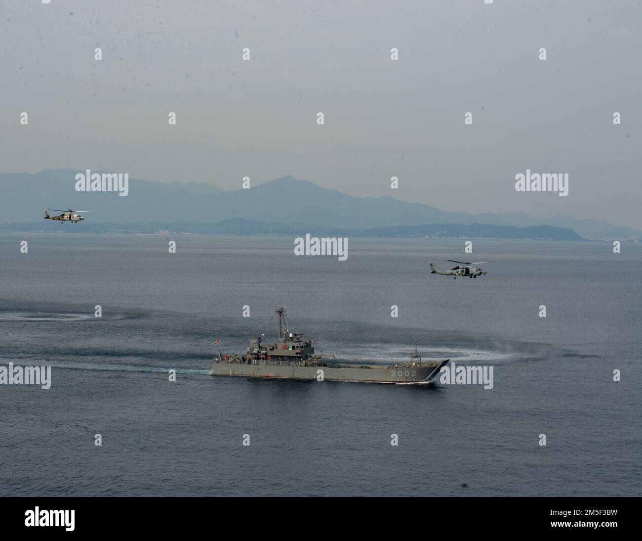 BAIE DE TOKYO (10 mars 2022) un faucon MH-60R, attaché aux “Saberhawks” de l’Escadron de frappe maritime (UGH) 77, vole aux côtés d’un SH-60K affecté au “Mighty 59” de l’Escadron de développement aérien (VX) 51 de la Force d’autodéfense maritime du Japon (JMSDF), Et le navire utilitaire JS Yusotei 2-Go (LCU 2002) avant le premier exercice de torpille mené par un américain Escadron de la Marine à côté de la JMSDF. La HSM-77 est rattachée au commandant de la Force opérationnelle 70 et déployée à l'avance dans la zone d'opérations de la flotte américaine 7th à l'appui d'une Indo-Pacific libre et ouverte. Banque D'Images