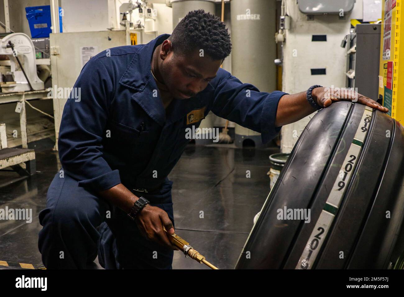 MER DES PHILIPPINES (11 mars 2022) Airman Everette Isom, de Rock Hill, S.C., vérifie la pression d'air sur un pneu à bord du porte-avions de la classe Nimitz USS Abraham Lincoln (CVN 72). Abraham Lincoln Strike Group est en cours de déploiement prévu dans la zone d'exploitation de la flotte américaine 7th afin d'améliorer l'interopérabilité par le biais d'alliances et de partenariats tout en servant de force de réaction prête à l'emploi pour soutenir une région libre et ouverte d'Indo-Pacifique. Banque D'Images