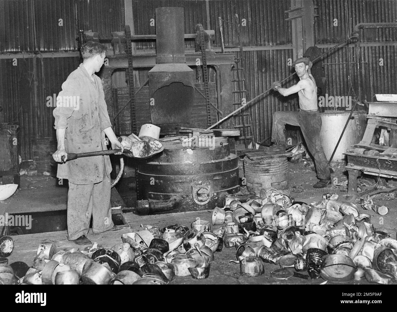 Une sélection de pots et de bouilloires en aluminium sont mis dans la fonderie dans un atelier en Grande-Bretagne lors d'une opération de récupération en 1940. Banque D'Images