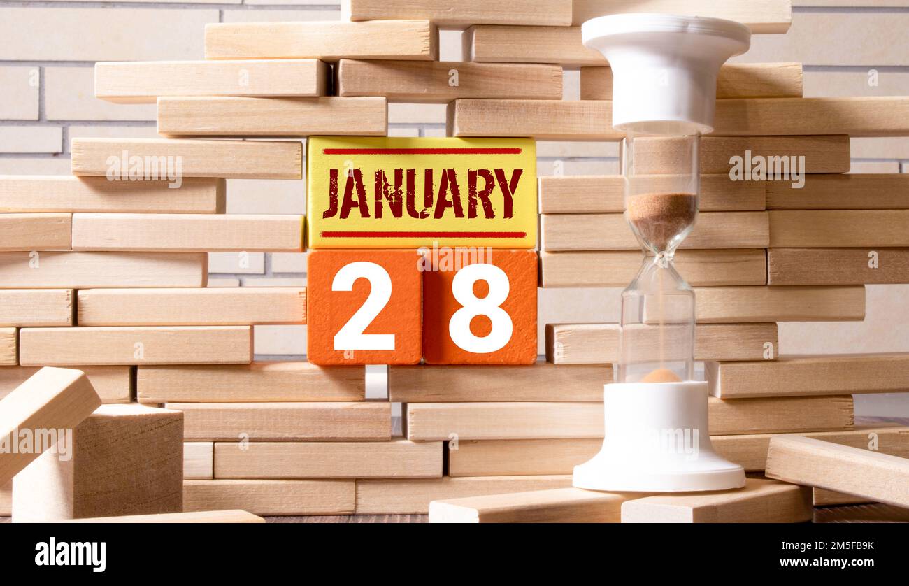 Texte de date du calendrier 28 janvier sur des blocs de bois avec parc d'arrière-plan flou. Concept d'espace de copie et de calendrier. Banque D'Images