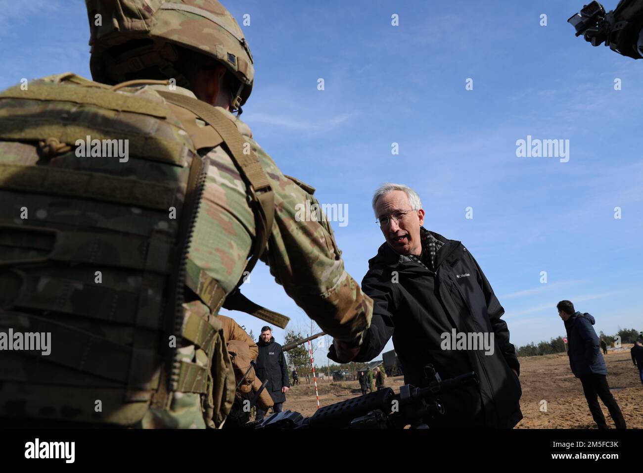 ÉTATS-UNIS L'ambassadeur en Lettonie, John L. Carwile, tremble avec les États-Unis Ryan Phelan, SPC de l'armée, lors de l'exercice multinational, Sabre Strike 22, sur 11 mars 2022 à Adazi, en Lettonie. Cet exercice améliore la préparation militaire et les relations entre les alliés de l'OTAN dans la région européenne. (Photo des États-Unis Sergent d'état-major de l'armée Matthew Brown) Banque D'Images