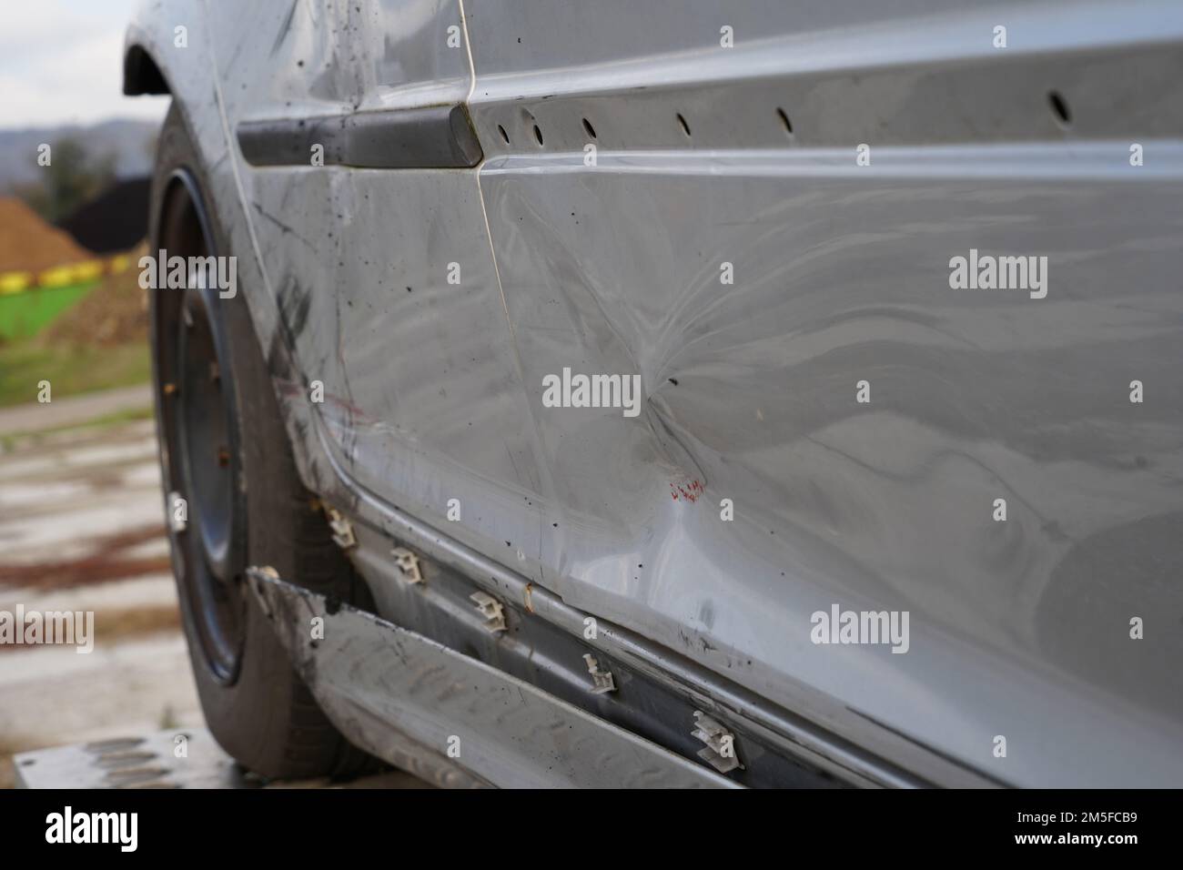 Vue rapprochée des dommages causés par une voiture argentée à l'arrière et sur les côtés du véhicule. Banque D'Images