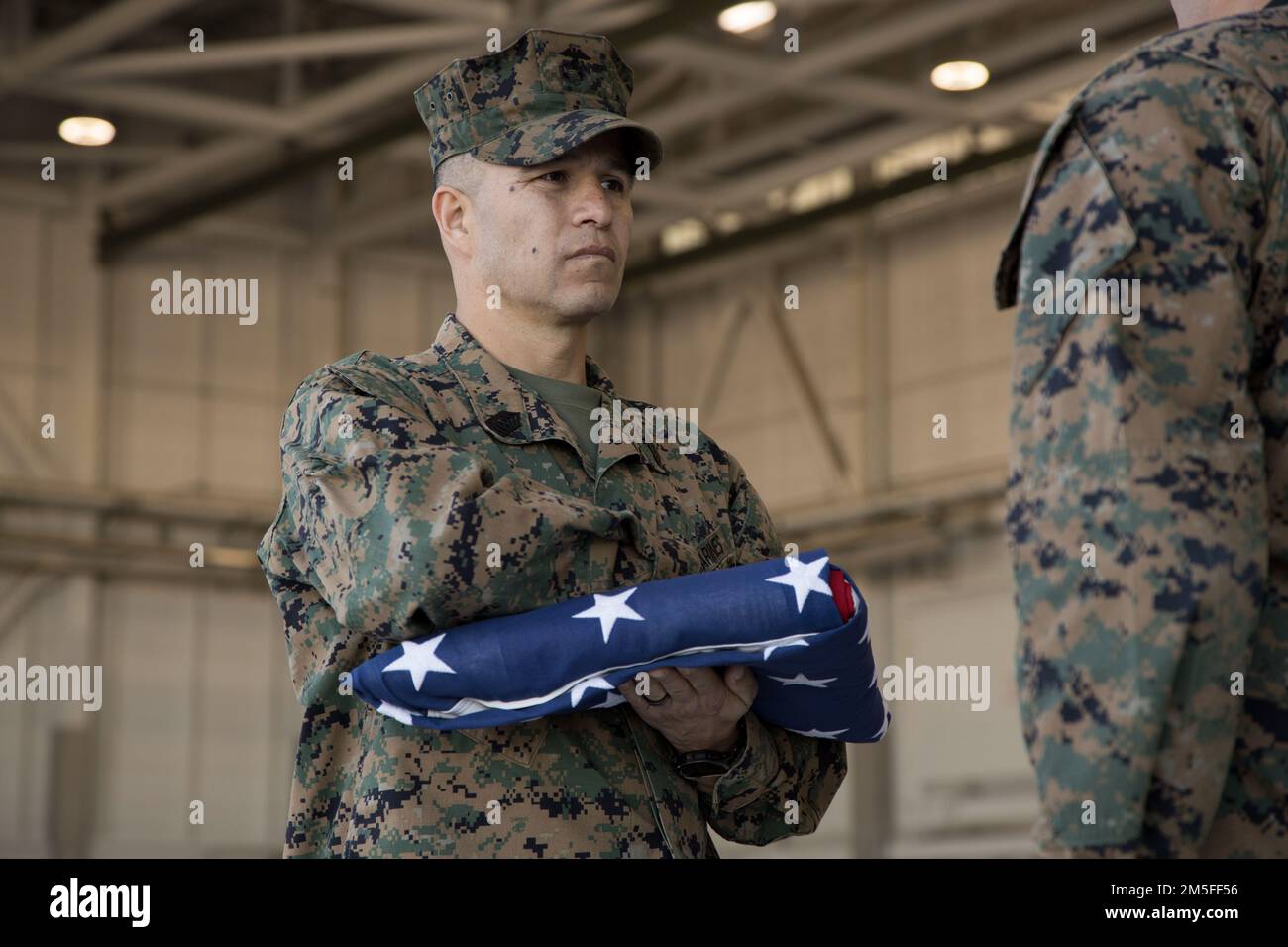 ÉTATS-UNIS Le Sgt. Samuel Martinez, chef de l'ordonnance d'aviation, Escadron d'essais et d'évaluation opérationnels maritimes 1 (VMX-1), détient le drapeau américain lors de sa cérémonie de retraite à la station aérienne du corps maritime Yuma, Arizona, 11 mars 2022. La cérémonie de la retraite s'est terminée par la lecture de la Vieille gloire et le passage du drapeau américain. Martinez a pris sa retraite après 21 ans de service dans le corps des Marines. Banque D'Images