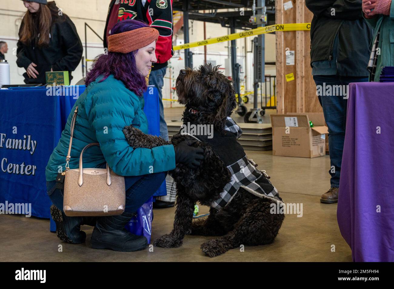 Un membre de la famille d’un militaire accepte un chien de service lors d’un événement de la Journée du conjoint à la base aérienne de Little Rock, Arkansas, 12 mars 2022. Les conjoints militaires et leurs familles ont eu l'occasion de faire une tournée du C-130J pendant l'événement et de participer à un vol d'orientation à bord de l'avion. Banque D'Images