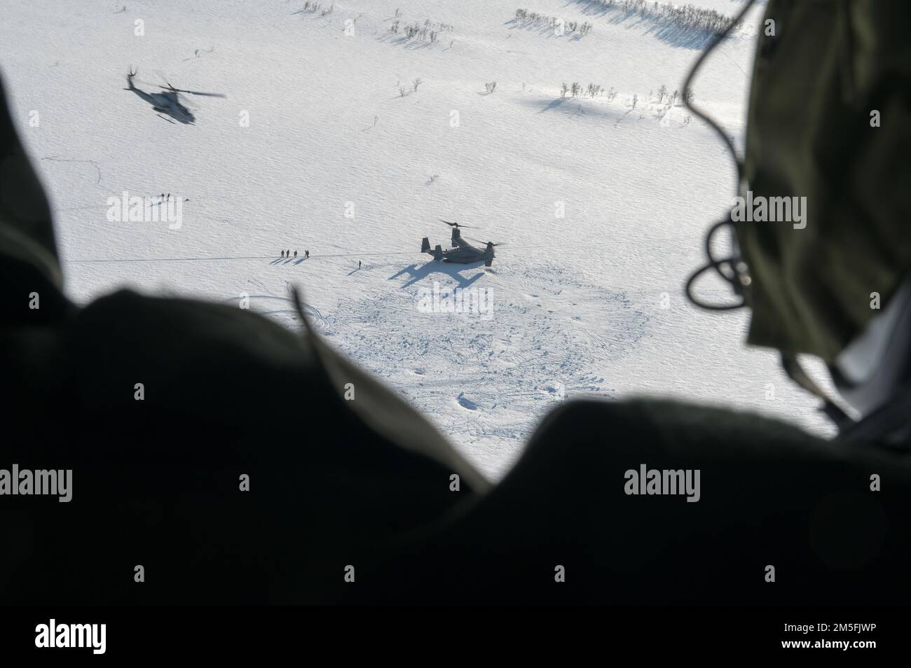 Une marine américaine avec l'aile d'avions marins 2nd à bord d'un UH-1Y Venom fournit une surveillance aux côtés d'un AH-1W Super Cobra tandis qu'un US Air Force CV-22B Osprey affecté à l'escadre d'opérations spéciales 352d débarquant dans une zone d'atterrissage de combat hostile simulée, le 12 mars 2022, Au cours de l'exercice Cold Response «22 dans le nord de la Norvège. Cette formation a été menée afin de mieux familiariser chaque unité avec les tactiques et les protocoles de l'autre. L'exercice Cold Response '22 est un exercice annuel de préparation nationale et de défense norvégien qui a lieu dans toute la Norvège, avec la participation de chacun de ses militaires Banque D'Images