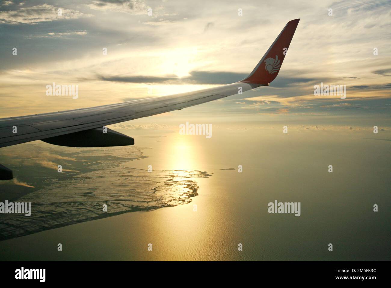 Une aile d'un avion passager exploité par l'Indonesia Lion Air est photographiée alors qu'elle survole la zone côtière de la province de Banten avant un atterrissage à l'aéroport international Soekarno-Hatta de Jakarta. Banque D'Images