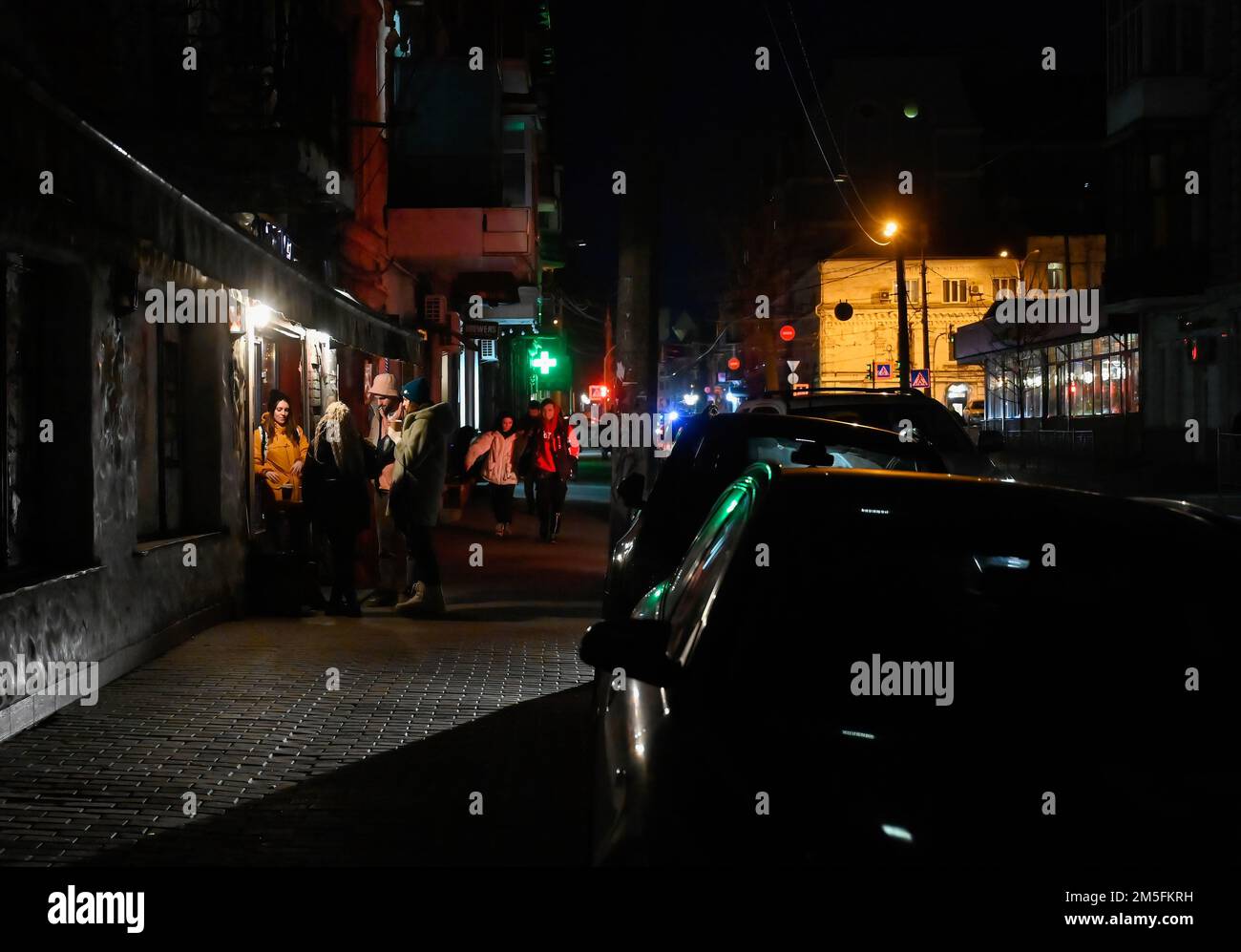 Kiev, Ukraine. 26th décembre 2022. Les gens boivent du café devant un café dans une rue sombre pendant une panne de courant à Kiev. L'armée russe a mené des attaques massives de roquettes et de drones kamikaze sur les infrastructures énergétiques ukrainiennes. Après de graves dommages au réseau électrique dans de nombreuses villes d'Ukraine, la compagnie nationale d'électricité Ukrenergo a introduit des coupures d'électricité d'urgence et toutes les heures. (Photo par Sergei Chuzavkov/SOPA Images/Sipa USA) crédit: SIPA USA/Alay Live News Banque D'Images