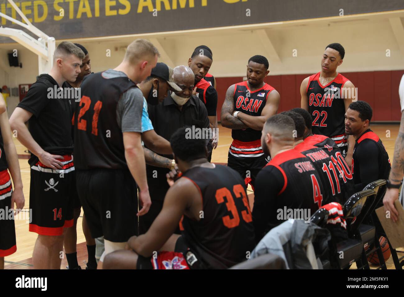 L'équipe de basket-ball d'Osan se réunit autour de son entraîneur lors d'un délai d'attente pour un match aux États-Unis Garnison militaire Humphreys 13 mars 2022. L'équipe se prépare à reprendre le jeu après le délai. Banque D'Images