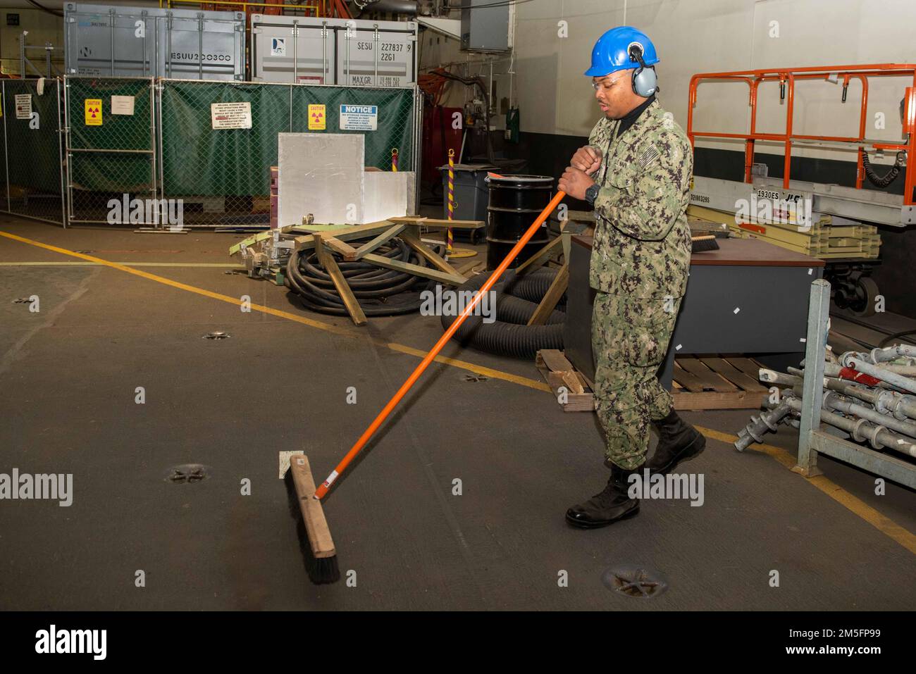 Aviation Boatswain’s Mate (Handling) Airman recrute Dallas Shaw, de Los Angeles, balaie le pont dans la baie hangar à bord du porte-avions USS John C. Stennis (CVN 74), à Newport News, Virginie, 14 mars 2022. Le John C. Sennis est à Newport News Shipyard travaillant aux côtés de NNS, de NAVSEA et d'entrepreneurs effectuant le ravitaillement et la révision complexe dans le cadre de la mission de livrer le navire de guerre dans le combat, dans les délais et dans le budget, pour reprendre son devoir de défendre les États-Unis. Banque D'Images