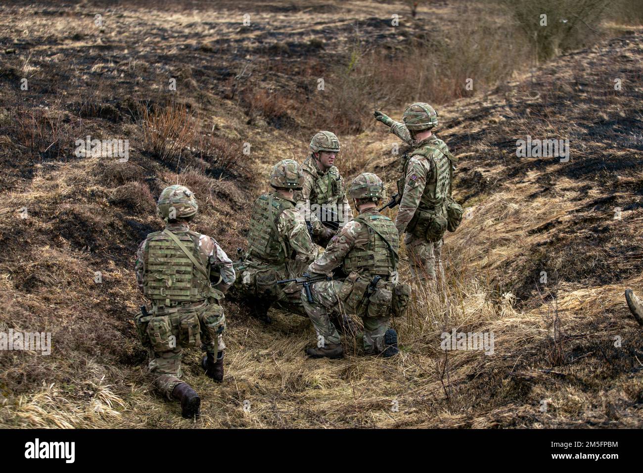 Les cadets des officiers de l'armée britannique de l'Académie militaire royale de Sandhurst s'entraînent dans un champ de tir en direct dans la zone d'entraînement de Grafenwoehr du Commandement de l'instruction militaire des États-Unis 7th, Grafenwoehr, Allemagne, 14 mars 2022. Les cadets de l'officier ont passé la semaine à grafenwoehr en combinant les différents concepts de compétences de combat rapproché démontés qu'ils avaient appris jusqu'à présent dans un exercice combiné qui les oblige à travailler ensemble et à réfléchir rapidement pour atteindre un objectif. Banque D'Images