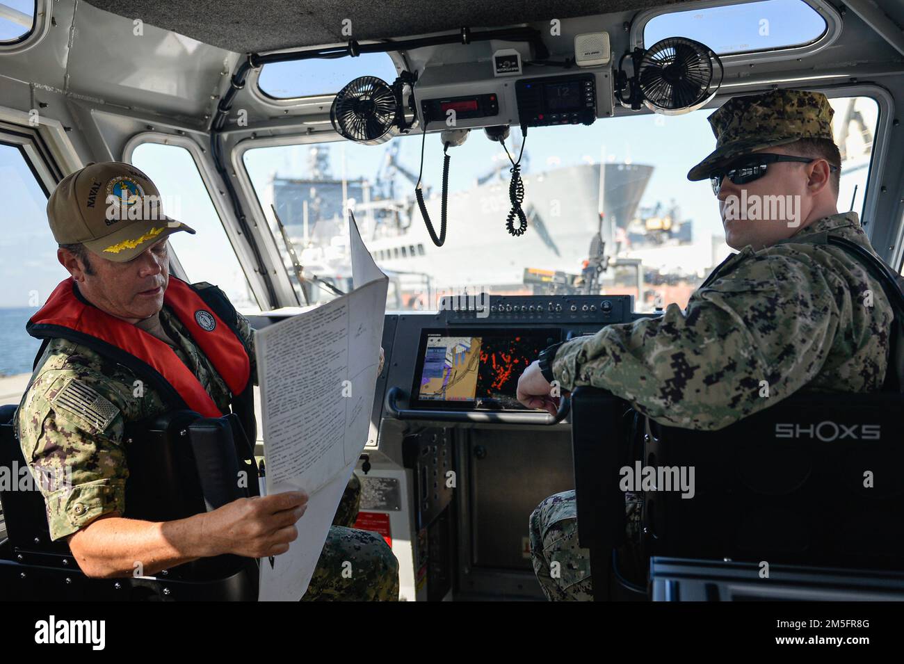 220314-N-MJ716-1059 BASE NAVALE de SAN DIEGO (14 mars 2022) le capitaine Ted Carlson (à gauche), commandant de la base navale de San Diego (NBSD), effectue un contrôle de parcours dans un bateau de sécurité « requin métallique » avec l'unité de patrouille portuaire de la NBSD (UHP). L’UHP patrouille le périmètre de la baie de la base et est responsable du maintien de la sécurité des navires, des jetées et du personnel sur le front de mer. La NBSD célèbre 100 ans d'exploitation à San Diego depuis qu'elle a été levée en 1922. Banque D'Images