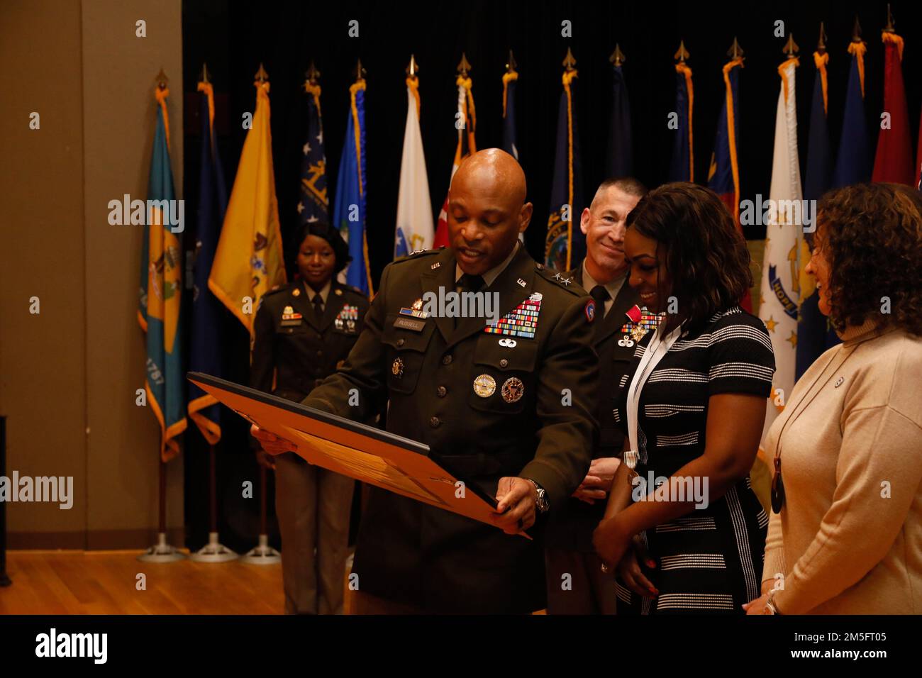 Le général de division Michel M. Russell Sr., commandant général du 1st Theatre Suresment Command, présente un cadeau à Razell Perry, épouse du sergent de commandement Michael J. Perry III, lors d'une cérémonie de renonciation à la responsabilité à fort KNOX, Kentucky, 15 mars 2022. Russell remercie Mme Perry et sa famille pour leur soutien et leur sacrifice continus. Banque D'Images