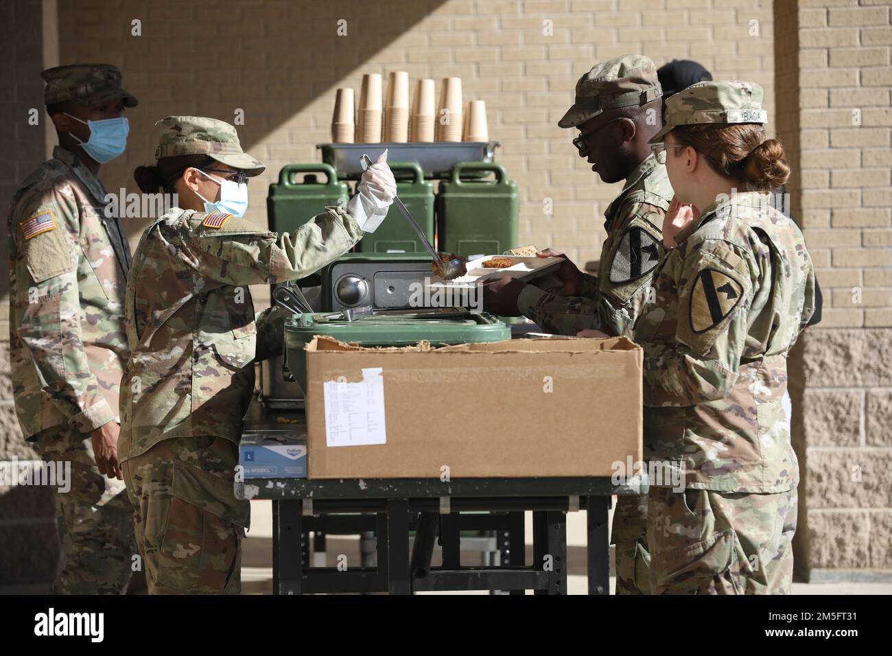 Des spécialistes culinaires de l’équipe de combat de la Brigade blindée 1st nourrissent les troopeurs à l’aide d’équipement d’alimentation sur le terrain lors de la coupure de courant post-générale de fort Hood le 15 mars. S'assurer que les troopers, qui sont détenteurs de cartes de repas, ont toujours eu l'occasion de recevoir trois repas tandis que les restaurants et les restaurants sur place sont restés fermés. (Photo des États-Unis Le sergent de l'armée Brayton Daniel, 1st, Division Cavalry, Bureau des affaires publiques) Banque D'Images