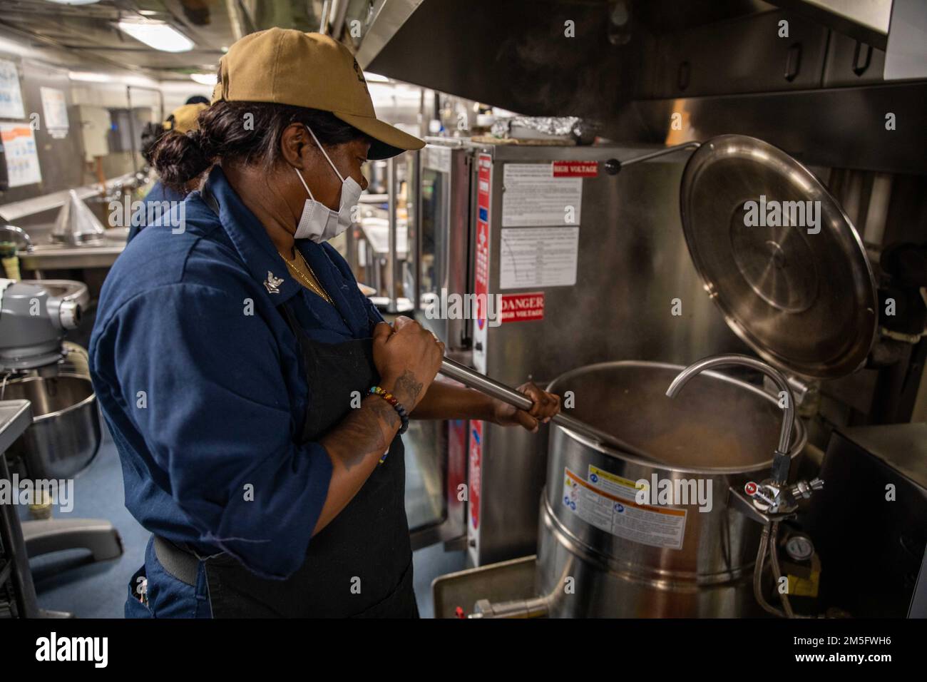 220315-N-HD110-1006 OCÉAN PACIFIQUE - (15 mars 2022) -- Spécialiste culinaire 2nd classe Alexandra Williams agite le pot rôti dans la cuisine à bord du navire de combat littoral Freedom-variant USS Milwaukee (LCS 5), 15 mars 2022. Milwaukee est déployée dans la zone d’opérations de la flotte américaine 4th pour appuyer la mission de la Force opérationnelle interagences conjointe Sud, qui comprend des missions de lutte contre le trafic de drogues illicites dans les Caraïbes et le Pacifique oriental. Banque D'Images