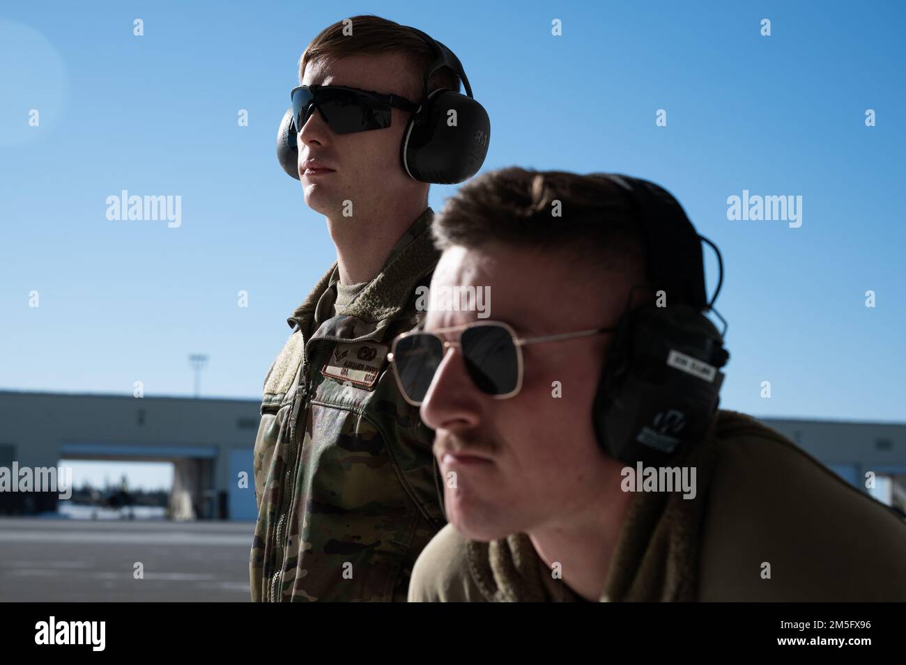 ÉTATS-UNIS Airman Aleksandr Zenski, un compagnon d'entretien de véhicule de l'escadron de préparation logistique 354th (à gauche), et Ian Sears, un chef d'équipage de l'unité d'entretien de 356th aéronefs, d'Airman 1st, se tiennent à côté lors d'une immersion « Chef d'équipage pour une journée » sur la base aérienne d'Eielson, en Alaska, au 15 mars 2022. Au cours de l’immersion, les chefs d’équipage «honoraires» accompagnent le personnel d’entretien au cours des inspections, du lancement, de la récupération et du ravitaillement des aéronefs affectés. Banque D'Images