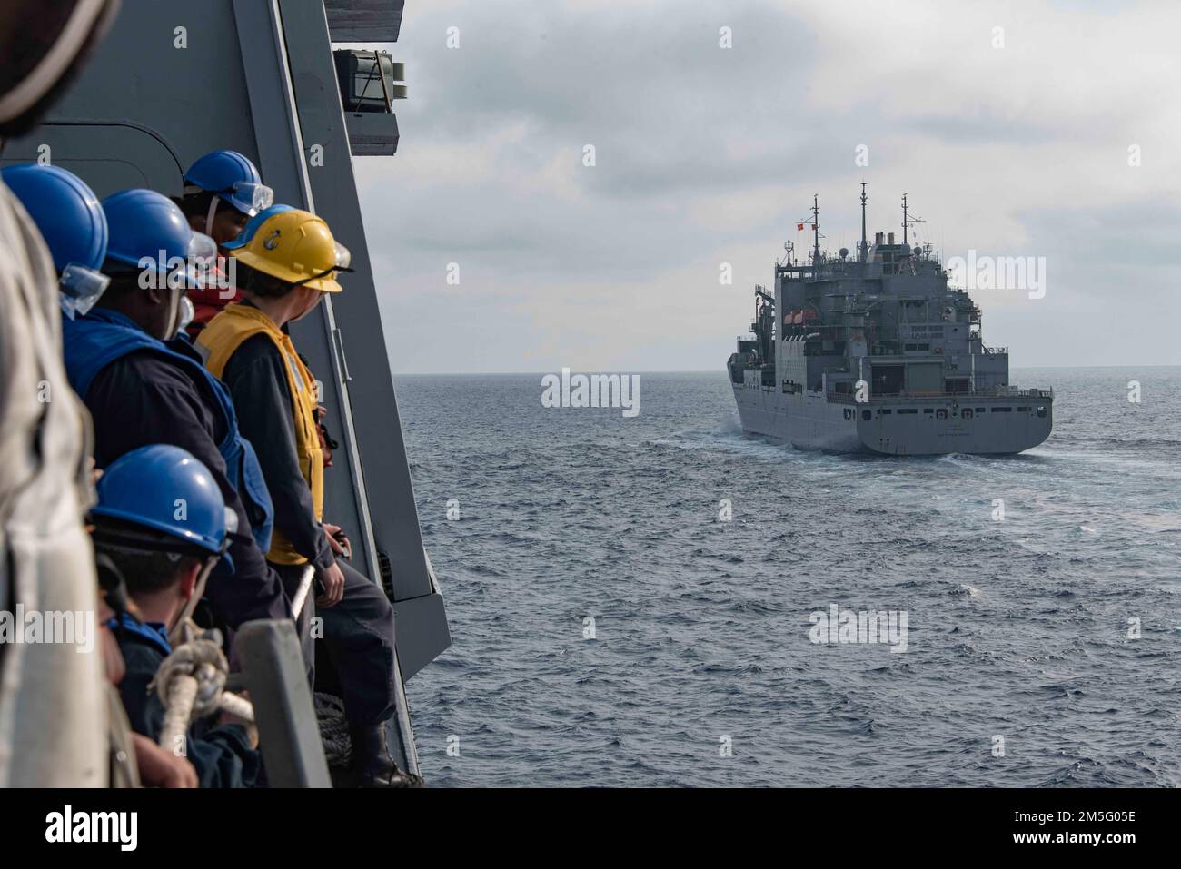 220315-N-XB010-1001 MER DE CHINE ORIENTALE (15 mars 2022) les marins affectés à l'USS New Orleans (LPD 28) se tiennent dans la vallée du bateau tout en approchant de l'USNS Matthew Perry (T-AKE 9) pour une certification de reconstitution en mer en cours. La Nouvelle-Orléans, qui fait partie de l'America Amphiobie Ready Group, ainsi que de l'unité expéditionnaire maritime 31st, opère dans la zone de responsabilité de la flotte américaine 7th afin d'améliorer l'interopérabilité avec les alliés et les partenaires et de servir de force de réaction prête à l'emploi pour défendre la paix et la stabilité dans la région Indo-Pacifique. Banque D'Images