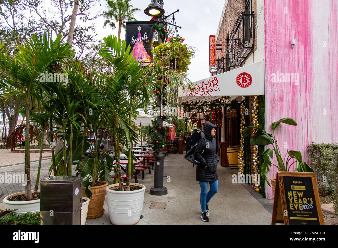 Une femme en manteau passe devant le restaurant Bodega Taqueria y Tequila lors d'une journée d'hiver exceptionnellement froide à West Palm Beach, Floride, États-Unis. Banque D'Images