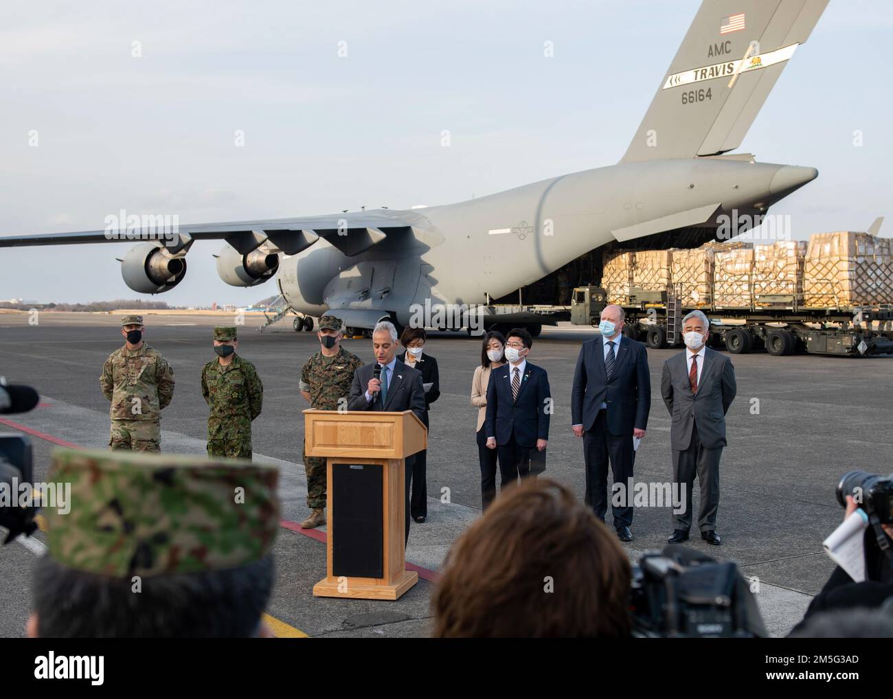 Rahm Emanuel, États-Unis Ambassadeur au Japon (au centre), parle lors d'une conférence de presse en tant qu'américain La Force aérienne C-17 Globemaster III charge des cargaisons d'aide humanitaire du gouvernement du Japon à la base aérienne de Yokota, Japon, 16 mars 2022. Emanuel a complimenté les efforts coordonnés du partenariat États-Unis-Japon pour fournir les fournitures humanitaires nécessaires à l'Ukraine, en déclarant que, quelle que soit la situation, les États-Unis, le Japon et l'Ukraine se tiennent ensemble comme des amis. Banque D'Images