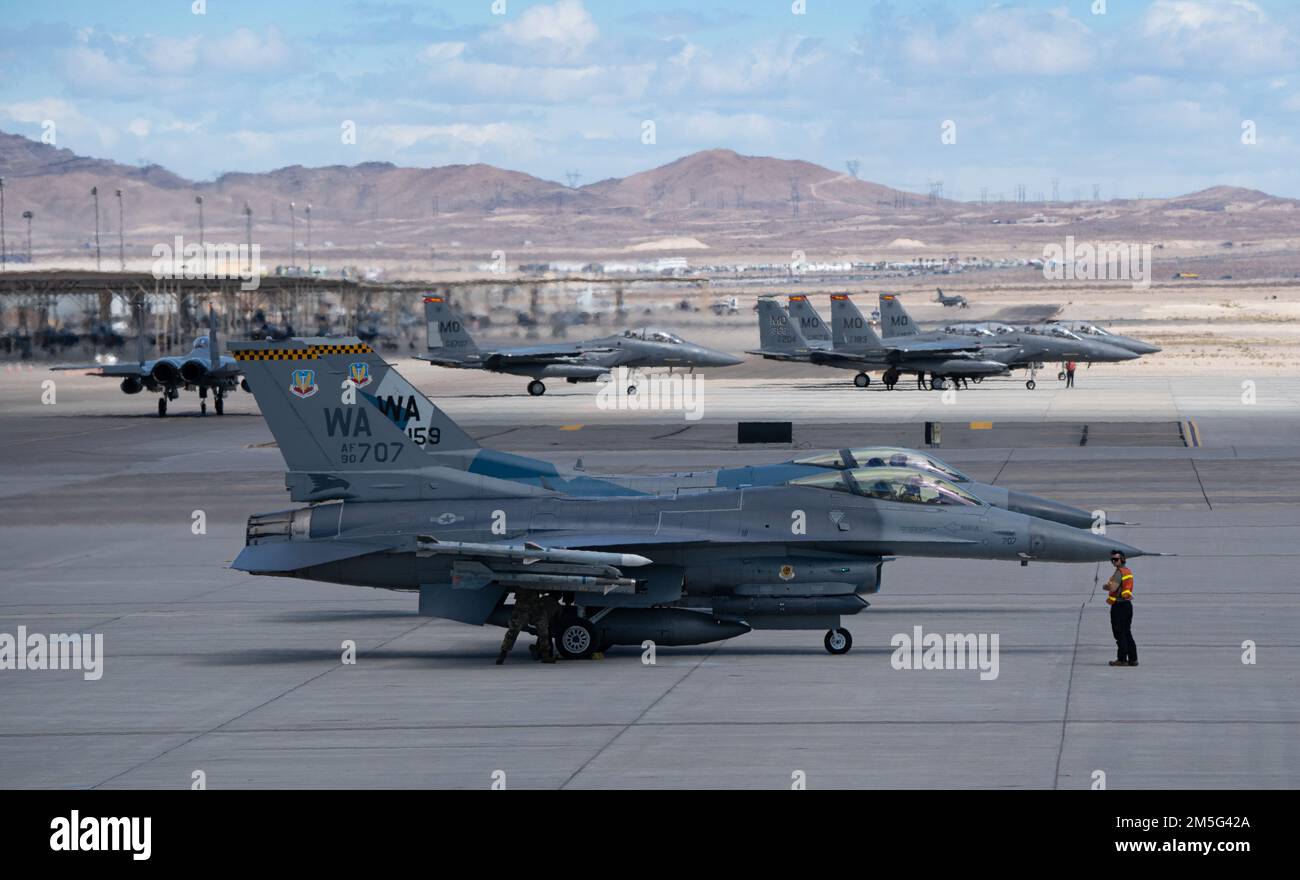 Deux faucon de combat F-16 de l'escadron 64th de l'agresseur, base aérienne de Nellis, Nevada, et six F-15Es de la base aérienne de Mountain Home, Idaho, attendent le décollage pour la mission Red Flag-Nellis 22-2 à la base aérienne de Nellis, Nevada, 16 mars 2022. Les exercices Red Flag offrent aux équipages l'expérience de multiples sorties de combat aérien intensives dans la sécurité d'un environnement d'entraînement. Banque D'Images