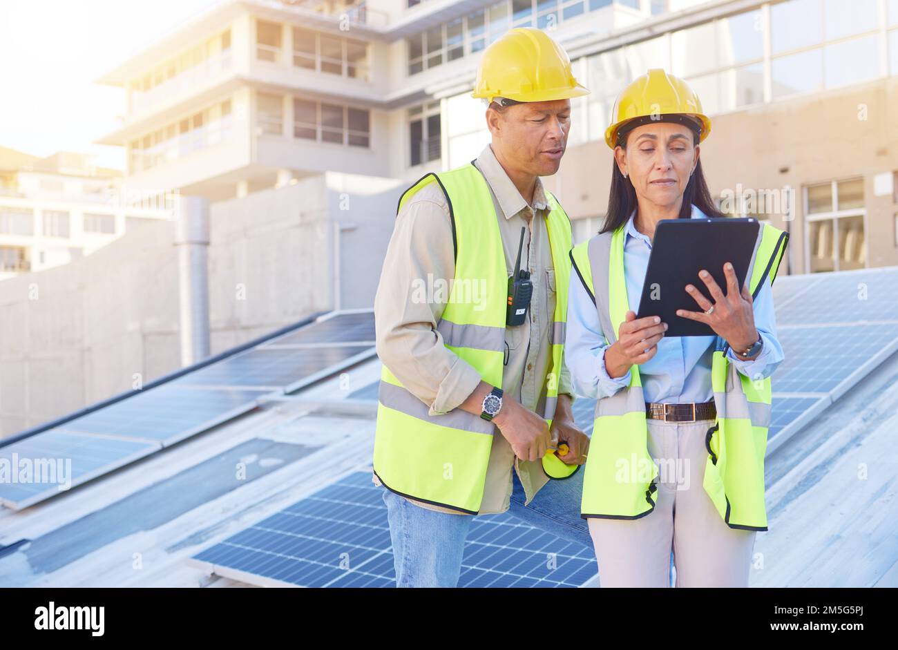 Ingénieur, homme et femme avec une tablette pour la recherche en ligne, le calendrier pour le projet de construction et la maintenance. Le numérique, les gens parlent et la construction Banque D'Images