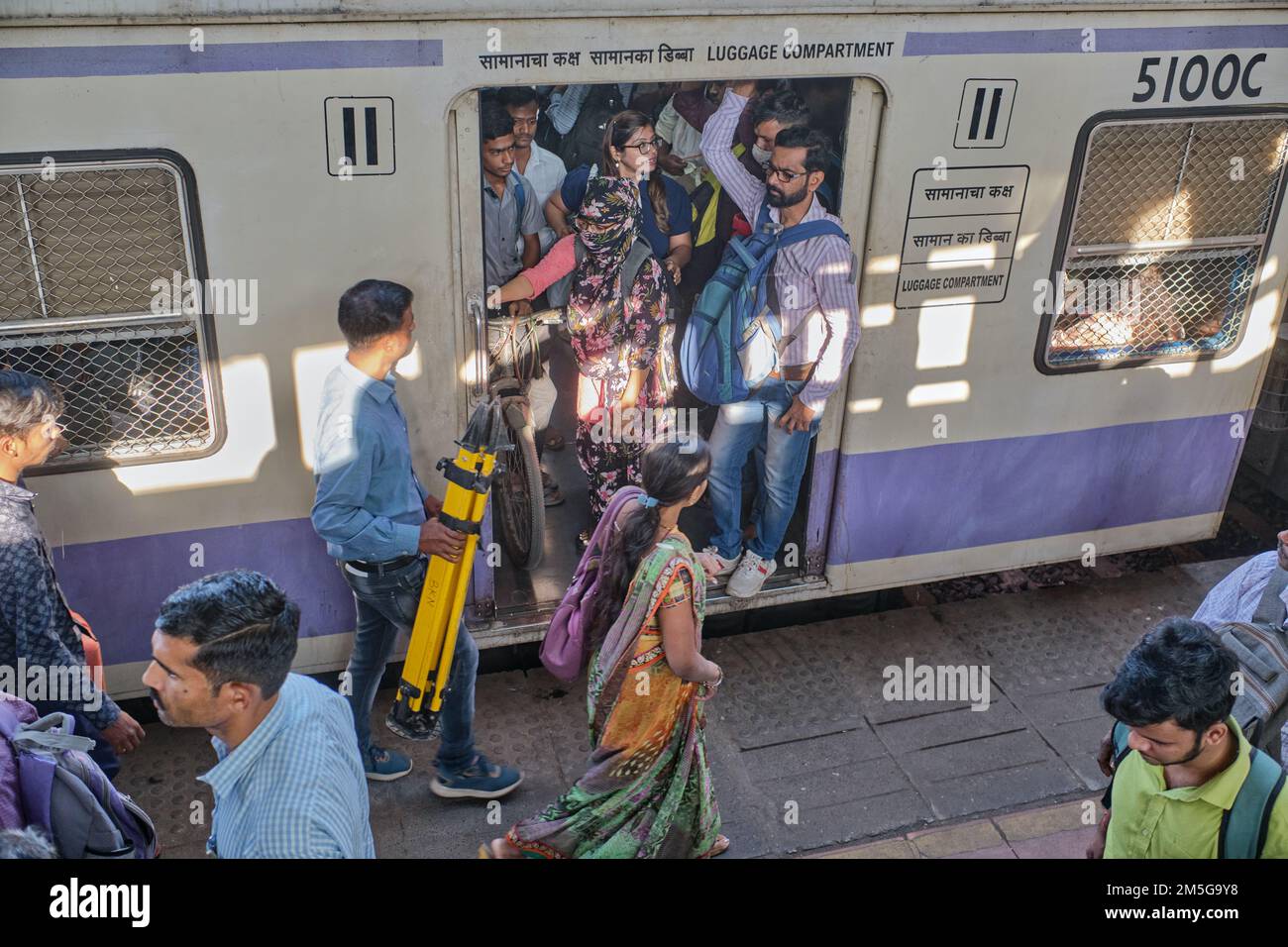 Un train de banlieue Western Railway local s'est arrêté à la gare de Dadar, Mumbai, Inde, les passagers bondés dans la porte ouverte du coffre à bagages Banque D'Images