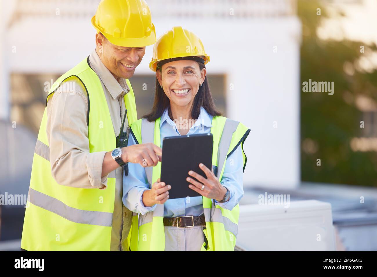 Ingénieur, homme et femme avec une tablette pour la recherche en ligne, le calendrier pour le projet de construction et la maintenance. Le numérique, les gens parlent et la construction Banque D'Images